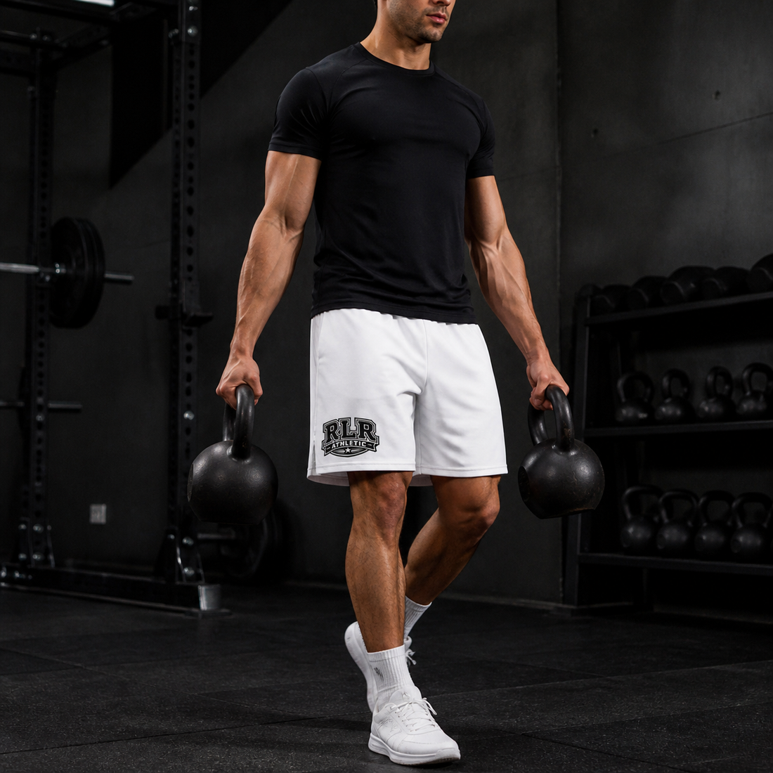 Athlete wearing white RLR Longline Training Shorts while carrying kettlebells in a dark gym